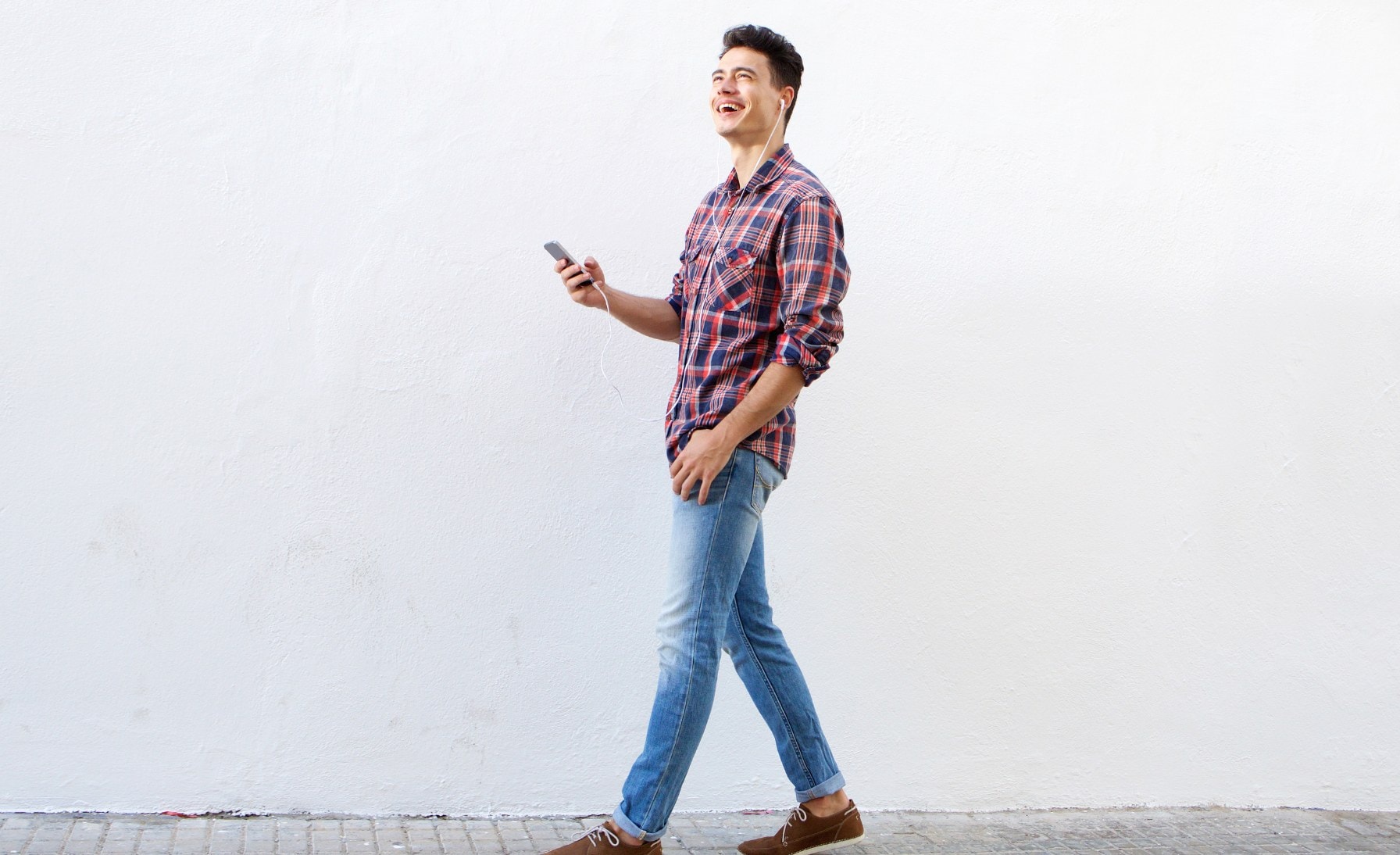 A confident young man walking outdoors with a full head of healthy hair, enjoying the sunshine and symbolizing hope after successful hair loss treatment.