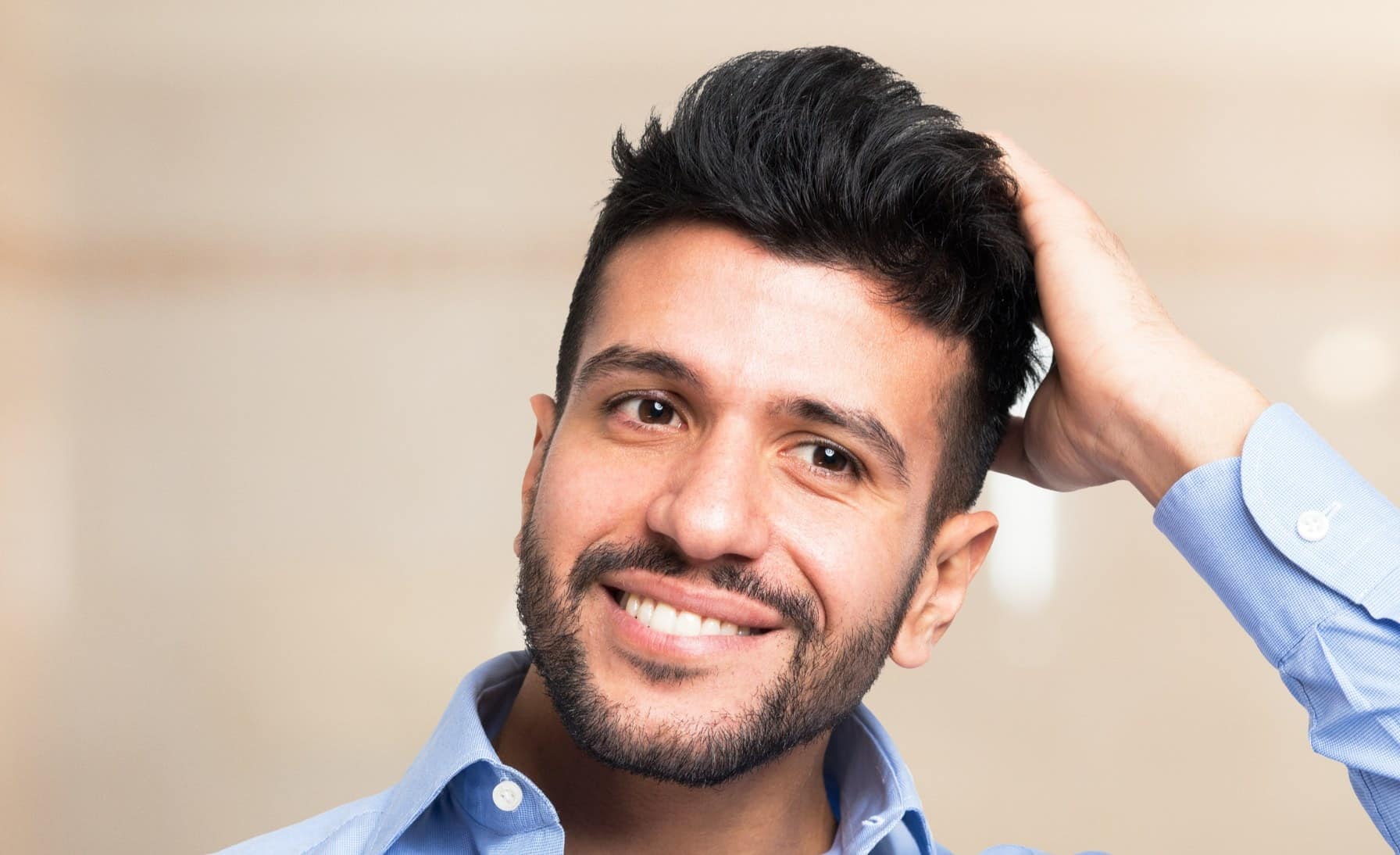 A smiling man having received a professional scalp treatment in a modern clinic, representing hair restoration solutions like or hair transplants.